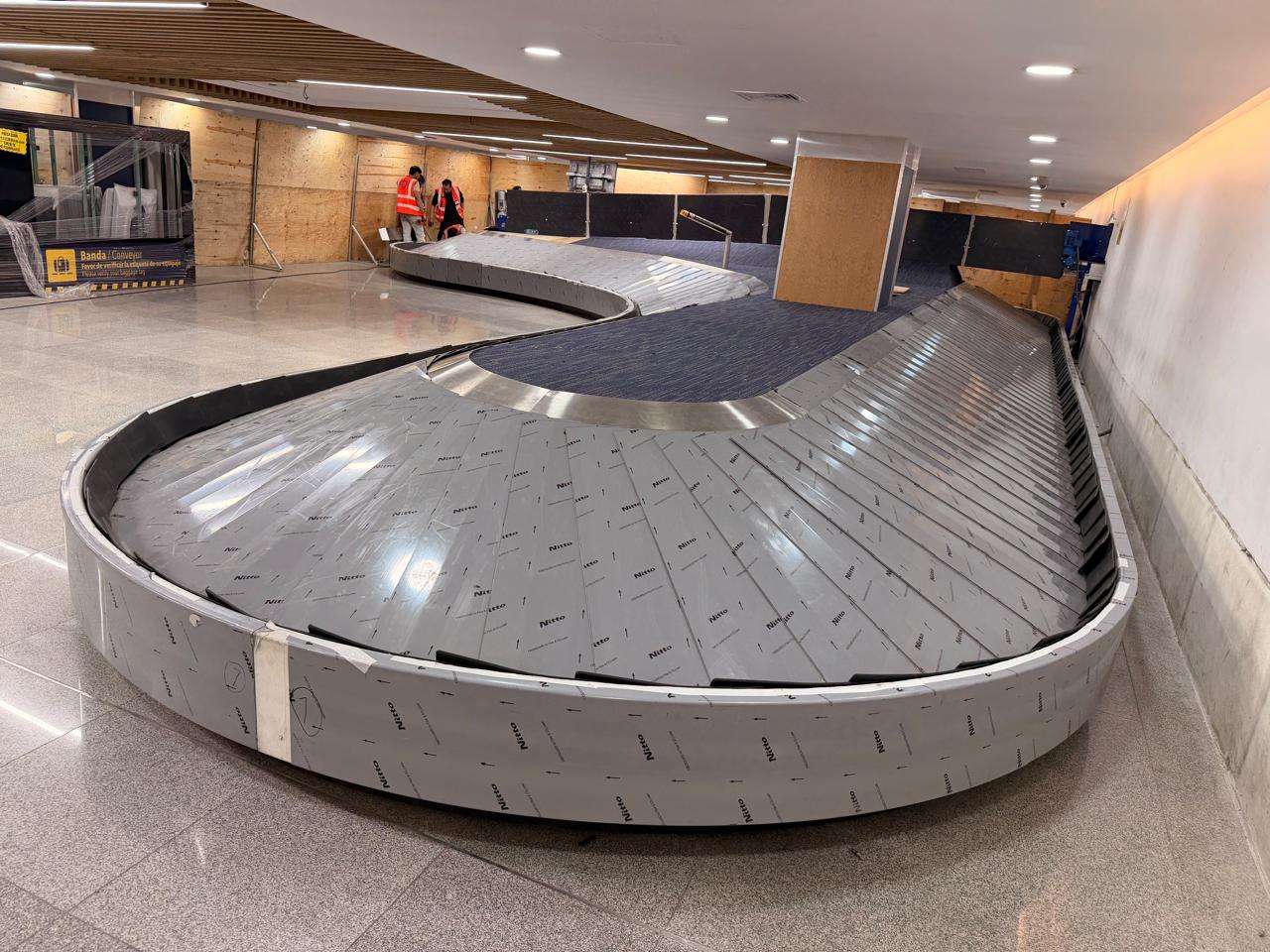 Banda tipo carrusel en proceso de fabricación o instalación dentro de terminal aeroportuaria