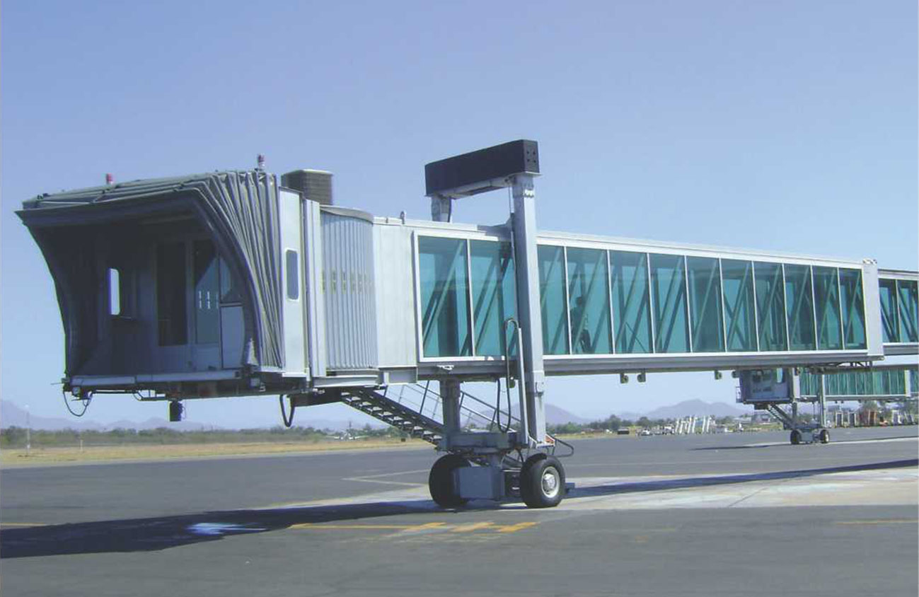 Pasillo telescópico instalado en plataforma aeroportuaria durante el día